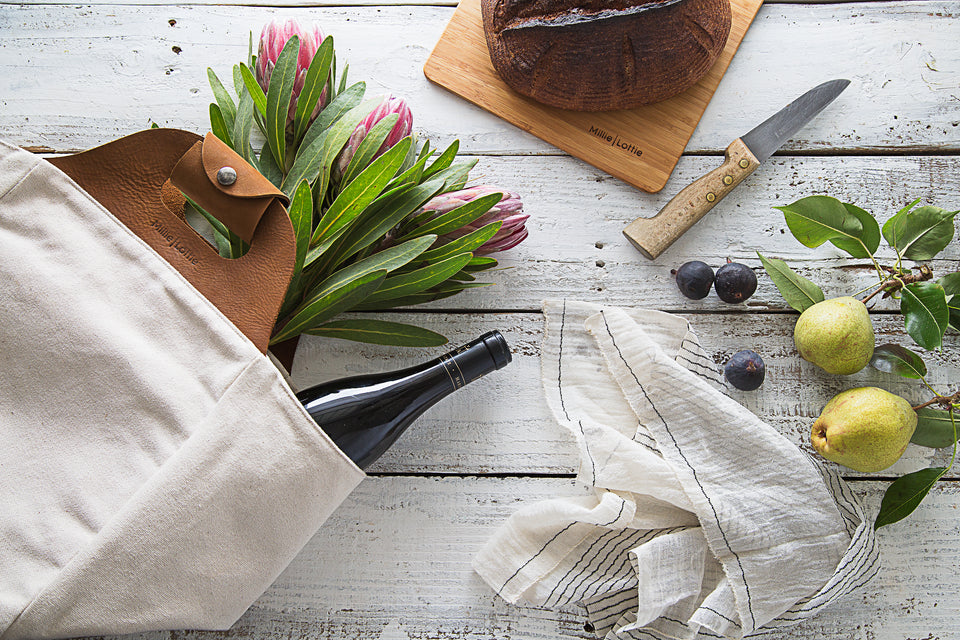Millie Lottie Eva Signature Food & Picnic Tote, Medium with Cutting Board, surrounded by flowers, bread and fruit