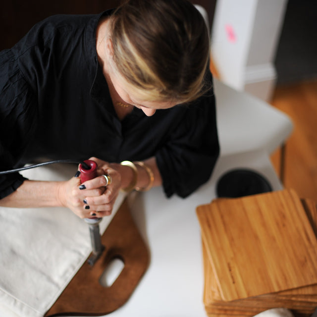 Jan the designer branding the totes with a hot branding iron