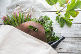 Eva Signature Wine & Picnic Tote on Table with wine and flowers peeking out